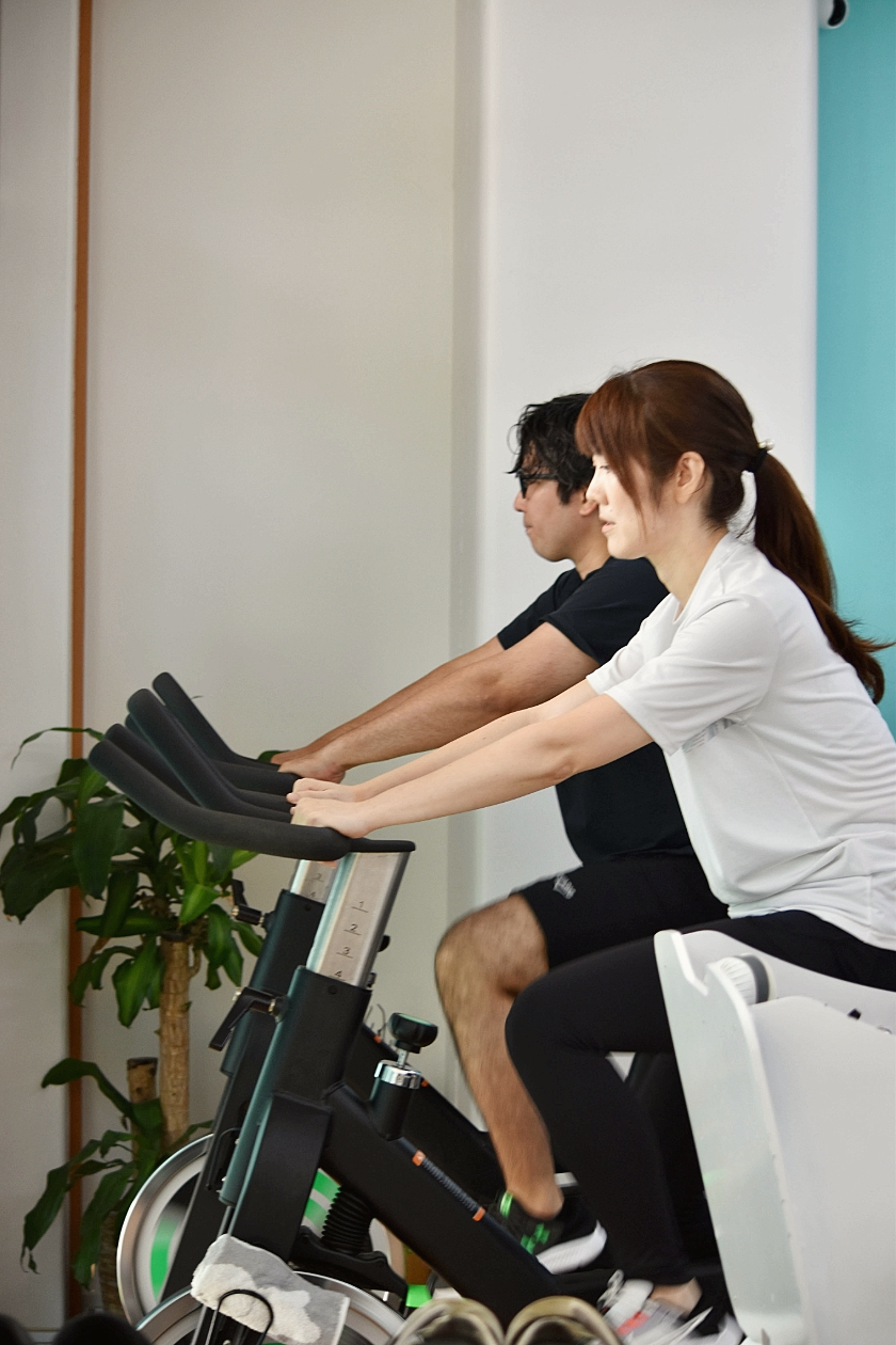 SHARK STYLE GYMで健康維持のためにエアロバイクを利用する様子